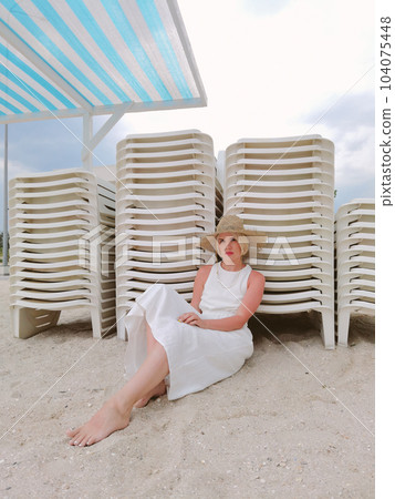 Portrait of boho woman wearing straw hat and fashionable summer clothes, posing on the beach. Sunset or Sunrise. Relax Portrait of boho woman wearing straw hat and fashionable summer clothes, posing on the beach. Sunset or Sunrise. Relax 104075448