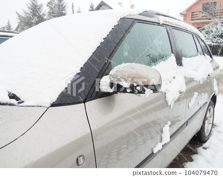 Snow and ice on the windshield, retrovisors and rear-view mirrors of the car. Winter driving conditions. Snow cleaning. Road traffic in winter. Metallic car. Snowdrifts and slush Snow and ice on the windshield, retrovisors and rear-view mirrors of the car. Winter driving conditions. Snow cleaning. Road traffic in winter. Metallic car. Snowdrifts and slush 104079470