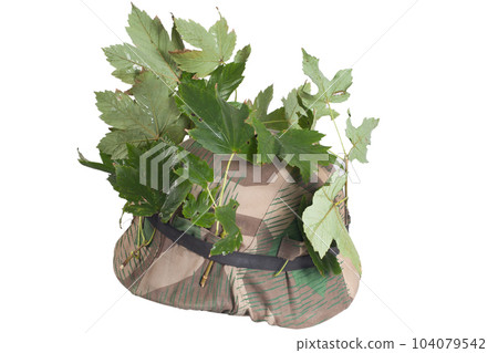 German Nazi Army steel helmet camouflaged with cover and tree leaves. World War II period 1933-1945. German Nazi Army steel helmet camouflaged with cover and tree leaves. World War II period 1933-1945. 104079542