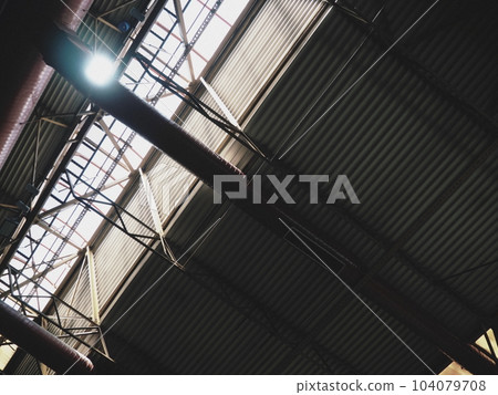 The roof of a hangar, a production hall or a sports hall. Metal structures, beams, supporting elements. Ventilation systems in large halls and rooms. Skylights. Industrial interior The roof of a hangar, a production hall or a sports hall. Metal structures, beams, supporting elements. Ventilation systems in large halls and rooms. Skylights. Industrial interior 104079708