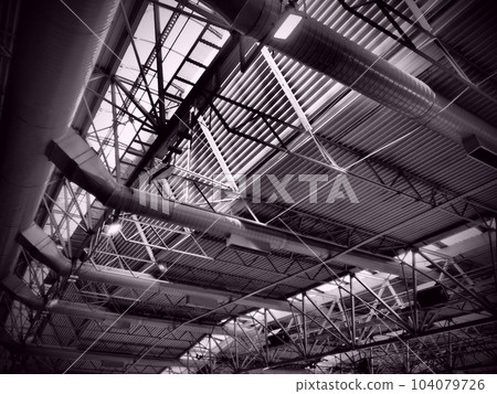 The roof of a hangar, a production hall or a sports hall. Metal structures, beams, supporting elements. Ventilation systems in large halls and rooms. Skylights. Industrial interior The roof of a hangar, a production hall or a sports hall. Metal structures, beams, supporting elements. Ventilation systems in large halls and rooms. Skylights. Industrial interior 104079726
