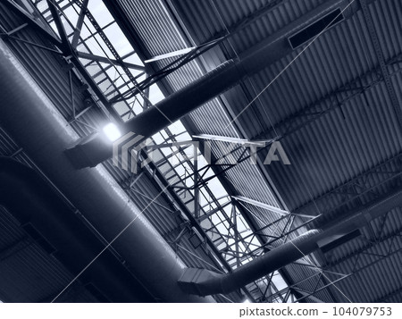 The roof of a hangar, a production hall or a sports hall. Metal structures, beams, supporting elements. Ventilation systems in large halls and rooms. Skylights. Industrial interior 104079753