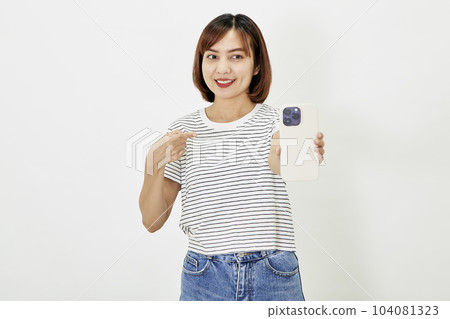 Young Asian female in t-shirt and blue jeans showing smartphone Young Asian female in t-shirt and blue jeans showing smartphone 104081323