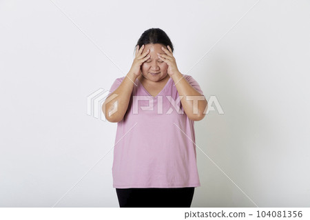 Beautiful Asian plus-size woman smiles with positive emotion, feeling happy and proud of her body overweight. Portrait shot on white background with copy space. Beautiful Asian plus-size woman smiles with positive emotion, feeling happy and proud of her body overweight. Portrait shot on white background with copy space. 104081356