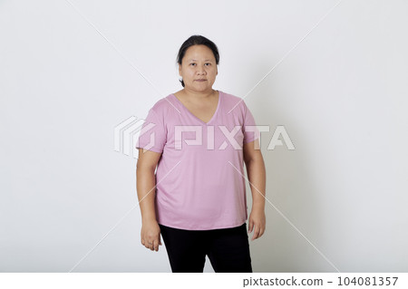 Beautiful Asian plus-size woman smiles with positive emotion, feeling happy and proud of her body overweight. Portrait shot on white background with copy space. Beautiful Asian plus-size woman smiles with positive emotion, feeling happy and proud of her body overweight. Portrait shot on white background with copy space. 104081357