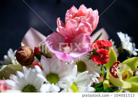 beautiful bouquet of different flowers close-up on a dark background 104081513