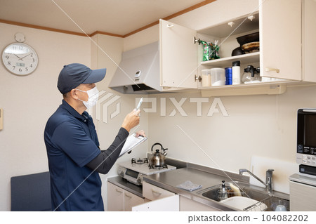 Male worker making an estimate for cleaning up the kitchen 104082202