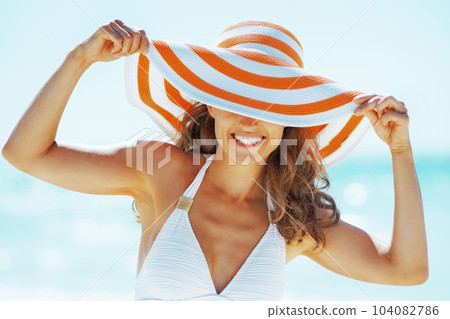 smiling young woman in hat on beach 104082786