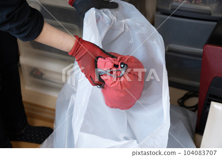 將不必要的物品放入垃圾袋的工人的手 104083707