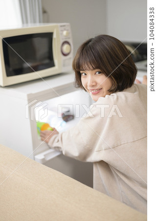 從冰箱裡拿出飲料的年輕女人 104084338