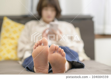 少婦在床上的看智能手機 104084339