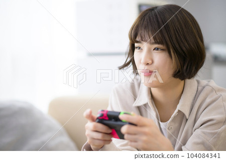 young woman playing video games young woman playing video games 104084341