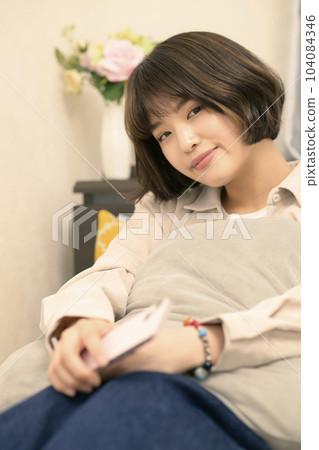 Young woman looking at smartphone in bed 104084346