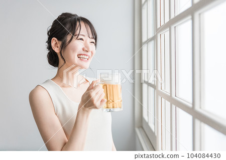 Asian woman drinking beer at home (beer mug) 104084430