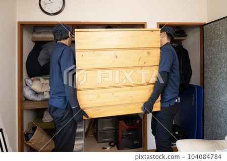 Two workers moving a closet 104084784