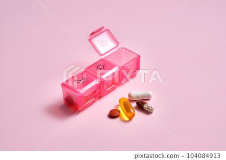 Bright pill box with different pills and vitamins. 104084913