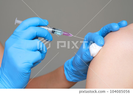 doctor's hand holds a syringe and a blue vaccine bottle at the hospital. Health and medical concepts. doctor's hand holds a syringe and a blue vaccine bottle at the hospital. Health and medical concepts. 104085056
