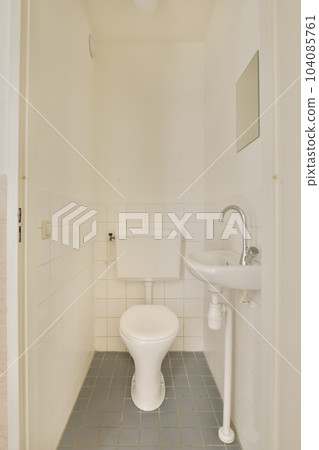 a bathroom that is white and has blue tiles on the floor, with a toilet in the corner next to the sink a bathroom that is white and has blue tiles on the floor, with a toilet in the corner next to the sink 104085761