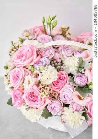 Flower arrangement in Wicker basket. Beautiful bouquet of mixed flowers on a marble table. Floral shop concept . Handsome fresh bouquet. Flowers delivery 104085769
