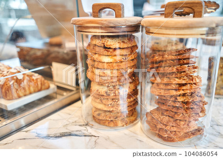 Oatmeal cookies on the marble kitchen table. Transparent glass jars with cookies in the interior of the cafe. Stylish interior of the kitchen of a trendy restaurant. decorative elements. Oatmeal cookies on the marble kitchen table. Transparent glass jars with cookies in the interior of the cafe. Stylish interior of the kitchen of a trendy restaurant. decorative elements. 104086054
