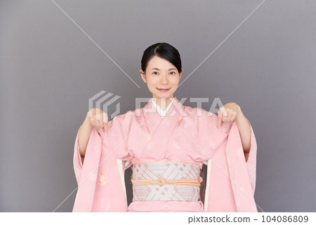 一個穿著和服的女人用手指指著 104086809