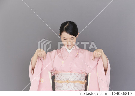 一個穿著和服的女人用手指指著 104086810