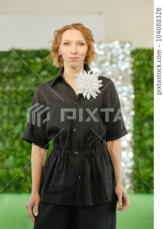 Cheerful middle-aged woman in linen pantsuit 104088326