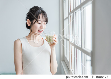 Asian woman who doesn't like vegetables drinking green smoothie at home (can't drink, not good at it, troubled, worried) Asian woman who doesn't like vegetables drinking green smoothie at home (can't drink, not good at it, troubled, worried) 104088374