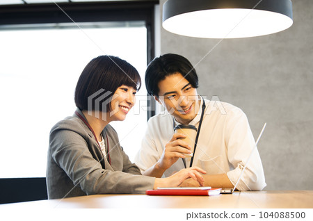 Male and female office workers meeting 104088500