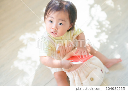 A baby with a picture book in his rucksack First rucksack 104089235