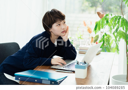 A young woman who is tired from working on a personal computer 104089285