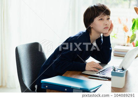一位厭倦了在個人電腦上工作的年輕女性 一位厭倦了在個人電腦上工作的年輕女性 104089291
