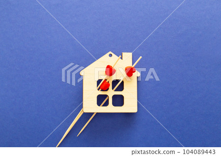 Wooden toy house with three red hearts on a blue background. Buying a house or family psychology Wooden toy house with three red hearts on a blue background. Buying a house or family psychology 104089443
