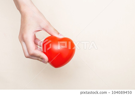 Children's hands holding a red heart as a simbol of care, love, support and protection 104089450