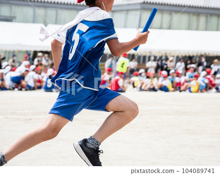 A child running a relay at an elementary school athletic meet 104089741