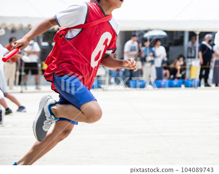 A child running a relay at an elementary school athletic meet 104089743