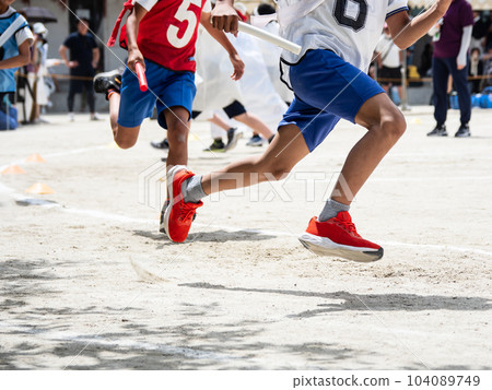A child running a relay at an elementary school athletic meet 104089749