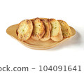 Several slices of garlic bread were placed on a wooden plate. 104091641