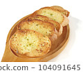 Several slices of garlic bread were placed on a wooden plate. 104091645