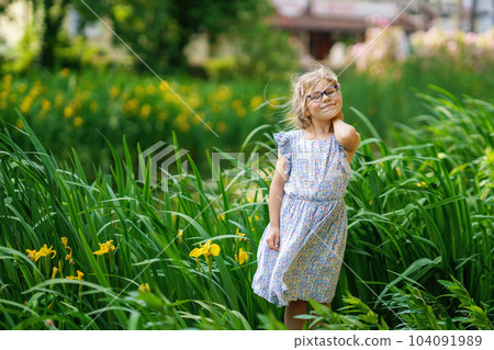 Portrait of a cute preschool girl with eye glasses outdoors in park. Happy funny child on sunny summer day. 104091989