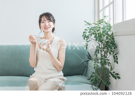 Asian women eating yogurt and dairy products on the sofa at home (bifidobacterium, lactic acid bacteria, dairy products, intestinal activity) Asian women eating yogurt and dairy products on the sofa at home (bifidobacterium, lactic acid bacteria, dairy products, intestinal activity) 104092126
