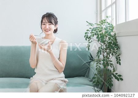 Asian women eating yogurt and dairy products on the sofa at home (bifidobacterium, lactic acid bacteria, dairy products, intestinal activity) Asian women eating yogurt and dairy products on the sofa at home (bifidobacterium, lactic acid bacteria, dairy products, intestinal activity) 104092127
