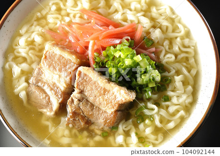 鳥瞰沖繩蕎麥麵,黑色背景上有排骨、大量小蔥和醃姜 鳥瞰沖繩蕎麥麵,黑色背景上有排骨、大量小蔥和醃姜 104092144