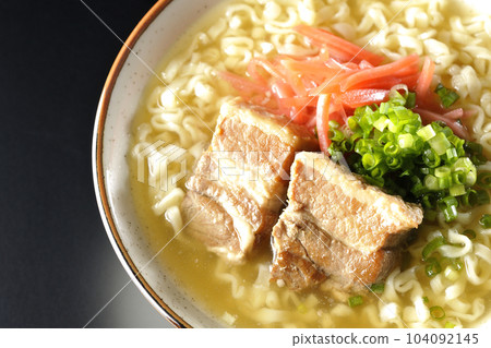 鳥瞰沖繩蕎麥麵,黑色背景上有排骨、大量小蔥和醃姜 鳥瞰沖繩蕎麥麵,黑色背景上有排骨、大量小蔥和醃姜 104092145