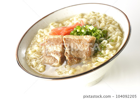 Okinawa soba with pork ribs, plenty of small green onions and pickled ginger, photographed against a white background 104092205