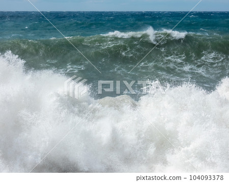 Large waves breaking on shore in Mediterranian sea during storm 104093378