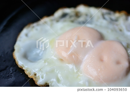 Fried twin eggs in an iron skillet Fried twin eggs in an iron skillet 104093650