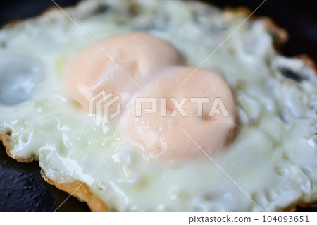 Fried twin eggs in an iron skillet 104093651