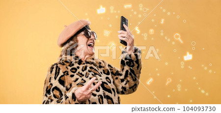 Cheerful aged woman in fashion clothes using smartphone and take a selfie 104093730