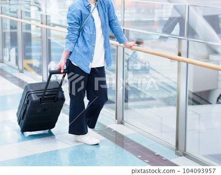 Image of a woman leaving for a trip with a suitcase at the airport 104093957